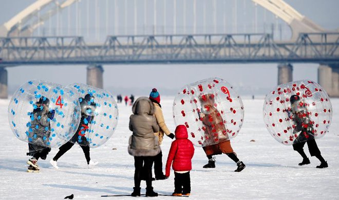 Tourists play on frozen Songhua River in NE China's Harbin