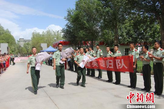 部隊官兵們迎接出院歸來的李運飛(中)和其他消防戰(zhàn)士?！⊥粲?攝